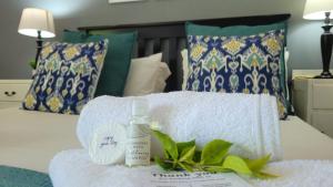 a pile of towels and a bottle of soap on a bed at Suite 14- Deja' Blu Bed and Breakfast- East London in East London