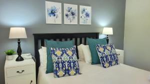 a bedroom with a bed with blue and white pillows at Suite 14- Deja' Blu Bed and Breakfast- East London in East London
