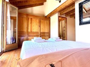 a bedroom with a large white bed with wooden cabinets at Estavar, Cerdanya, casa con piscina comunitaria in Estavar +27 photos
