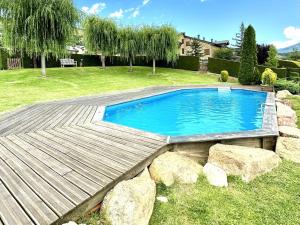 a swimming pool in a yard with a wooden deck at Estavar, Cerdanya, casa con piscina comunitaria in Estavar