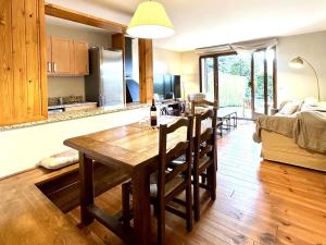 a kitchen and living room with a wooden table in a room at Estavar, Cerdanya, casa con piscina comunitaria in Estavar