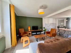 a living room with a couch and chairs and a table at 9 couchages - Proche Disneyland Paris in Ferrières-en-Brie