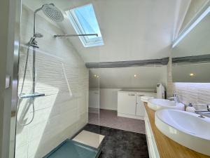 a bathroom with two sinks and a glass shower at 9 couchages - Proche Disneyland Paris in Ferrières-en-Brie +29 photos