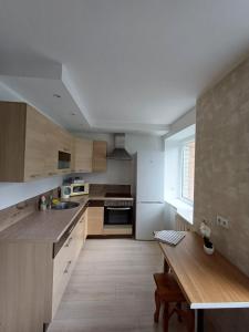 a kitchen with wooden cabinets and a wooden table at Narva mnt 28 in Jõhvi