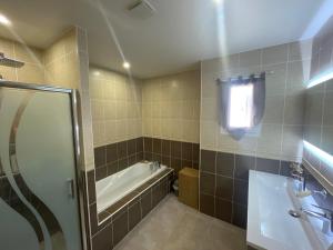 a bathroom with a tub and a shower and a sink at Occitania in Béziers