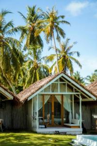 a house with palm trees in the background at La Belle Hollow Trees in Katiet