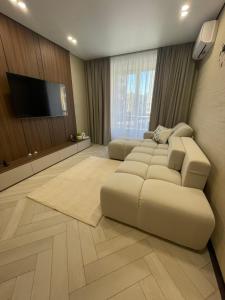 a living room with a couch and a flat screen tv at Апартаменти Оливкова симфонія in Zhytomyr