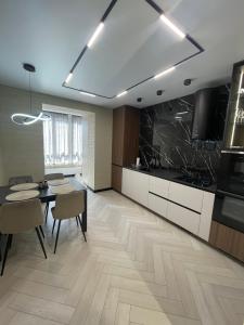 a kitchen with a table and chairs and a dining room at Апартаменти Оливкова симфонія in Zhytomyr