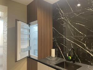 a bathroom with a sink and a black marble wall at Апартаменти Оливкова симфонія in Zhytomyr +28 photos