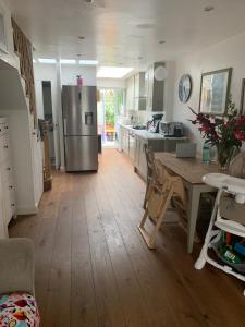 Una cocina con una mesa y un refrigerador de acero inoxidable. en Victorian House in the heart of Richmond, en Richmond upon Thames