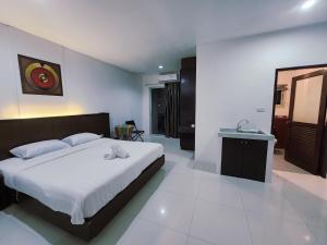 Un dormitorio con una cama grande y un lavabo en ALBADER HoTEL, en Patong Beach 6 fotos más