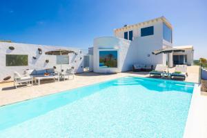 a villa with a swimming pool and a house at The View in Tías