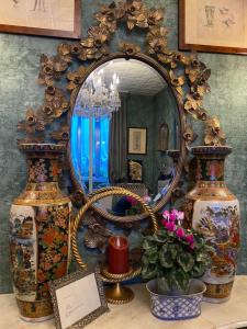 a mirror sitting on top of a table with vases at Venetian dream apartment in Venice +31 photos