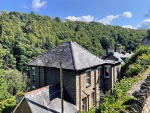 una vieja casa de ladrillo con techo en una colina en The Penthouse at Woodlands, en Lynton