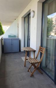 a wooden chair sitting next to a table on a patio at YamaLuxe Apartments - Modern & Cozy in Cluj-Napoca