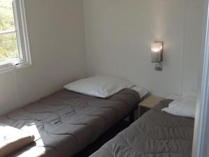 ein kleines Zimmer mit zwei Betten und einem Fenster in der Unterkunft Mobil home confortable avec terrasse - API-1-52-217 in Le Grand Serre + 17 Fotos