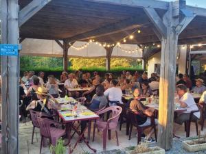 eine Gruppe von Personen, die auf einer Terrasse an Tischen sitzen in der Unterkunft Mobil home confortable avec terrasse - API-1-52-217 in Le Grand Serre