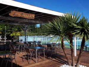 an outdoor restaurant with tables and chairs and palm trees at Mobil Home Confort 2 Chambres avec Terrasse - API-1-52-347 in Rives +23 photos