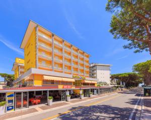 een geel gebouw aan de kant van een straat bij Hotel Sole in Rosolina Mare