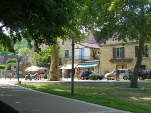 une rue avec des voitures garées sur le côté d'un bâtiment dans l'établissement Mobil home à Limeuil avec Terrasse - 5 pers. - API-1-52-308, à Limeuil