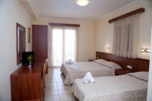 ein Hotelzimmer mit 2 Betten und einem TV in der Unterkunft Summertime Inn in Nikiana