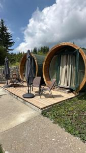 a circular wooden deck with chairs and a tent at Bungalows Tea Žabljak in Žabljak