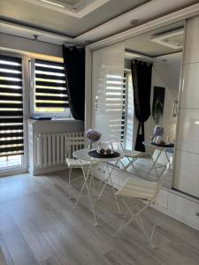 a dining room with a table and chairs and windows at Rooms near Balice airport in Cholerzyn
