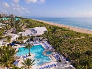 an aerial view of a resort with a swimming pool and the beach at Excellent beach front community, golf course, tennis, sunny weather year round! in Fort Pierce