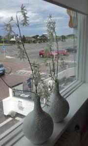 two vases sitting on a window sill with flowers at Pension 't hofje 350 meter van het strand in Noordwijk aan Zee
