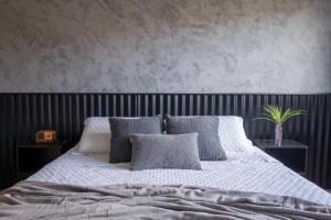 a bedroom with a large bed with gray and white pillows at Vila Piá 02 in Piaçabuçu