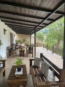 a patio with a wooden bench and a table at Forest House in Berat