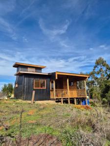 a house with a large deck on a hill at Casa Coguil - Camino Topocalma in Los Quillayes