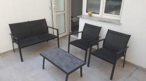 three black chairs and a table in front of a window at Espark baglar 1+1+ teraslı daire in Eskisehir