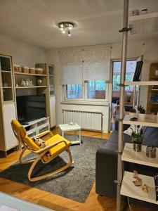 a living room with a yellow chair and a couch at Apartment 40 in Zagreb