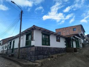 a building with green shutters on a street at La Posada de Elisea - Mongui in Monguí