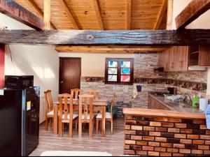 a kitchen with a table and chairs and a brick wall at La Posada de Elisea - Mongui in Monguí