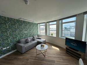 a living room with a couch and a tv at Bournemouth Lookout in Bournemouth