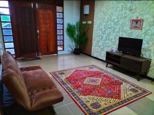 a living room with a chair and a rug at Amazon Berang Stay In in Kuala Berang