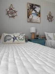Un dormitorio con una cama blanca con una almohada de estrella de mar. en The Old City Sunshine Retreat, en St. Augustine