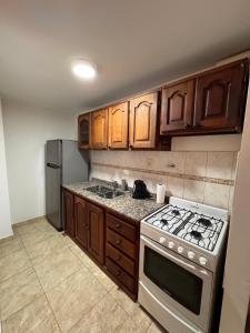 a kitchen with wooden cabinets and a stove and refrigerator at Patagonia 37 in Neuquén