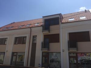 a building with a tiled roof and windows at INTRO Apartman in Sárvár