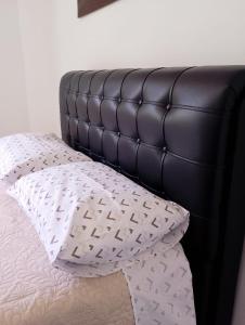 a black bed with a white pillow on it at Casa no Centro de São Lourenço in São Lourenço