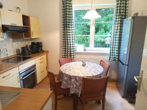 a kitchen with a table with chairs and a window at Ferienwohnung Finkenberg in Sebnitz