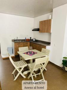 a dining room with a table and chairs in a kitchen at Mentto Hotel in Guaduas +17 photos