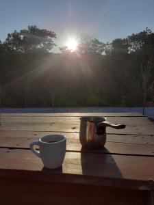 a cup and a coffee mug sitting on a wooden table at Stone House Rooms near Kavala in Amisianá