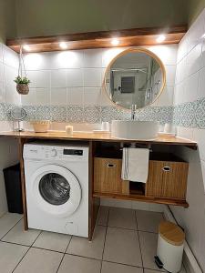 a bathroom with a washing machine and a mirror at Ti Paradis 1 in Les Trois-Îlets