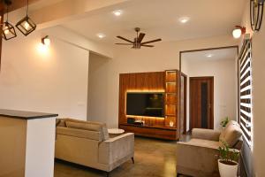 a living room with a couch and a television at Tranquil Touch in Chikmagalūr