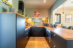 a kitchen with black cabinets and a wooden counter top at Sublime 180° d'Avignon Villeneuve Ventoux Alpilles in Villeneuve-lès-Avignon +14 photos