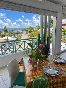 a table on a balcony with a view of the ocean at Ti Paradis 1 in Les Trois-Îlets