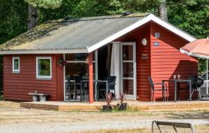 a red cabin with chairs and tables in it at 2 Bedroom Awesome Home In Nexø in Neksø